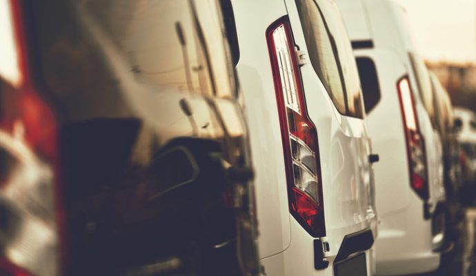 commercial VANs parked in row on dealership parking